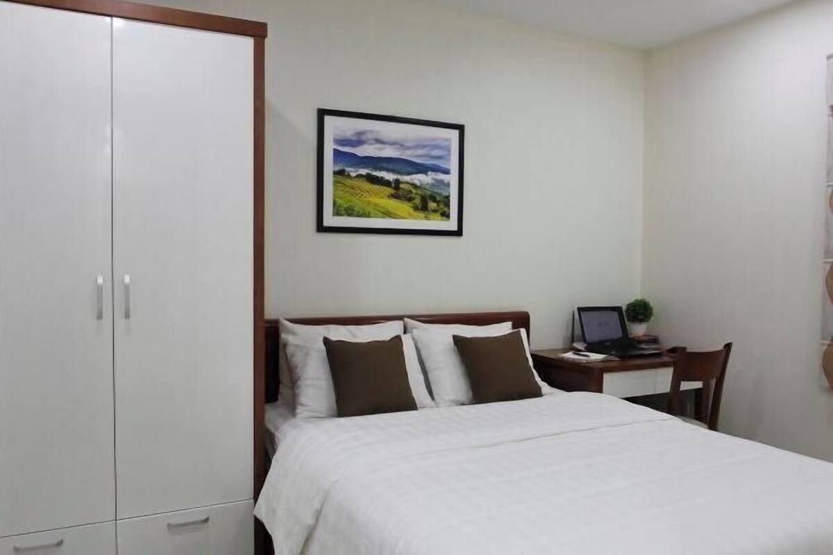 Premium bedding, desk, laptop workspace, blackout drapes