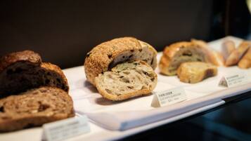 A display of various bread types with labels indicating names and prices.