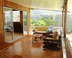 Un patio con suelo de madera, un sofá, una mesa y un banco.