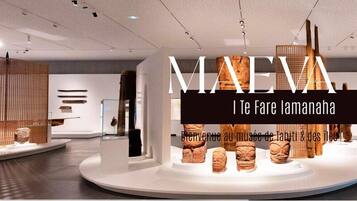 A modern interior with a central display of wooden artifacts and a welcoming sign.