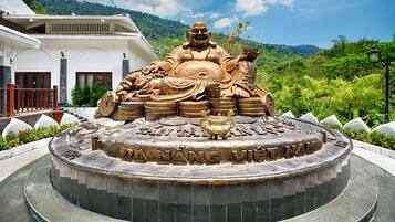 A large Buddha statue surrounded by coins, with the inscription "DA YANG VIET NAM" on a circular base.