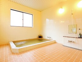Un bagno con una vasca da bagno spaziosa, una finestra e uno spazio doccia.