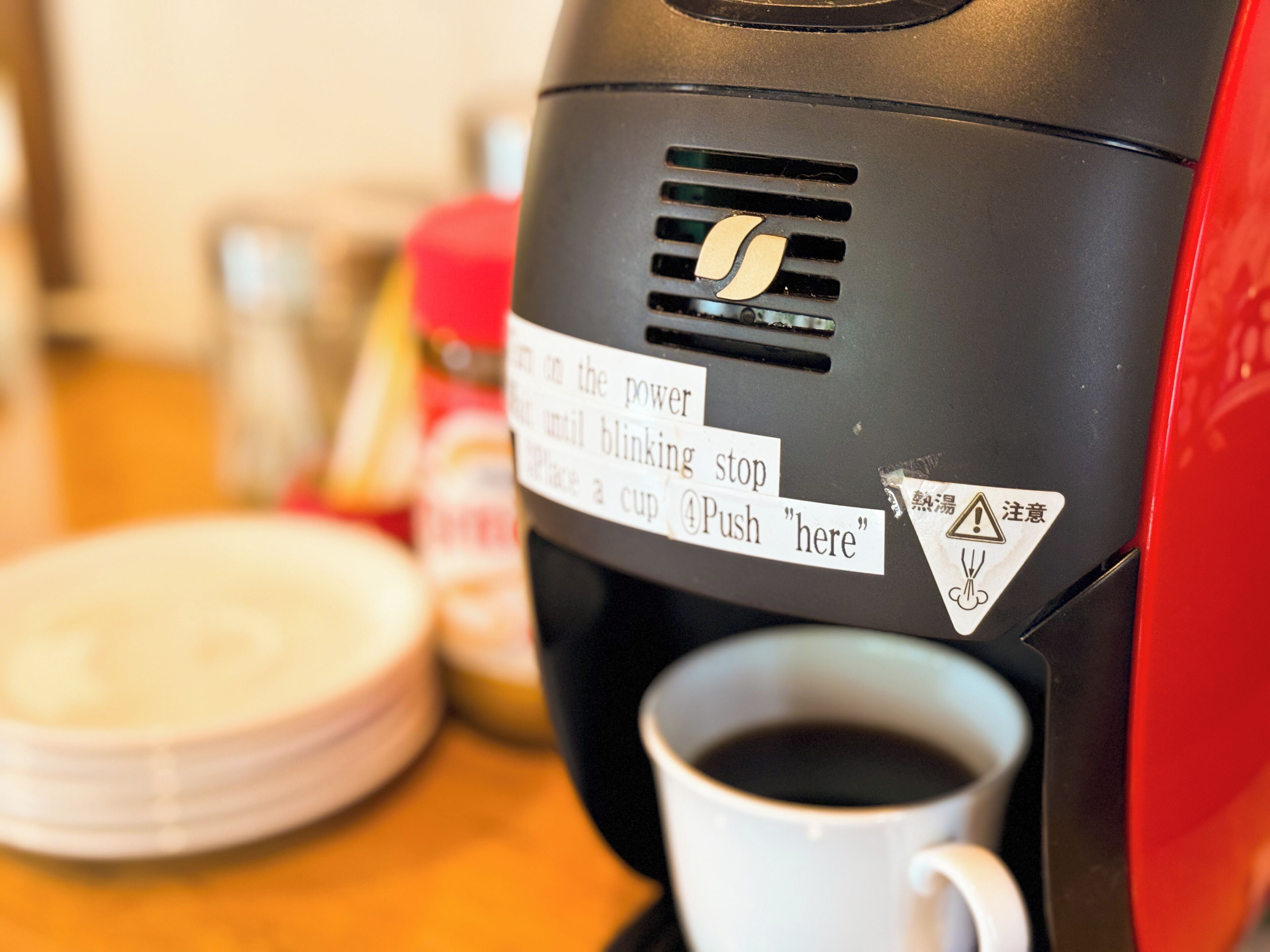 Eine Kaffeemaschine mit Gebrauchsanweisung und einer Tasse Kaffee.
