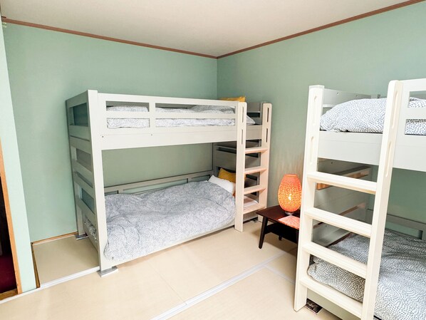 A room with bunk beds, a small table, and a lamp.