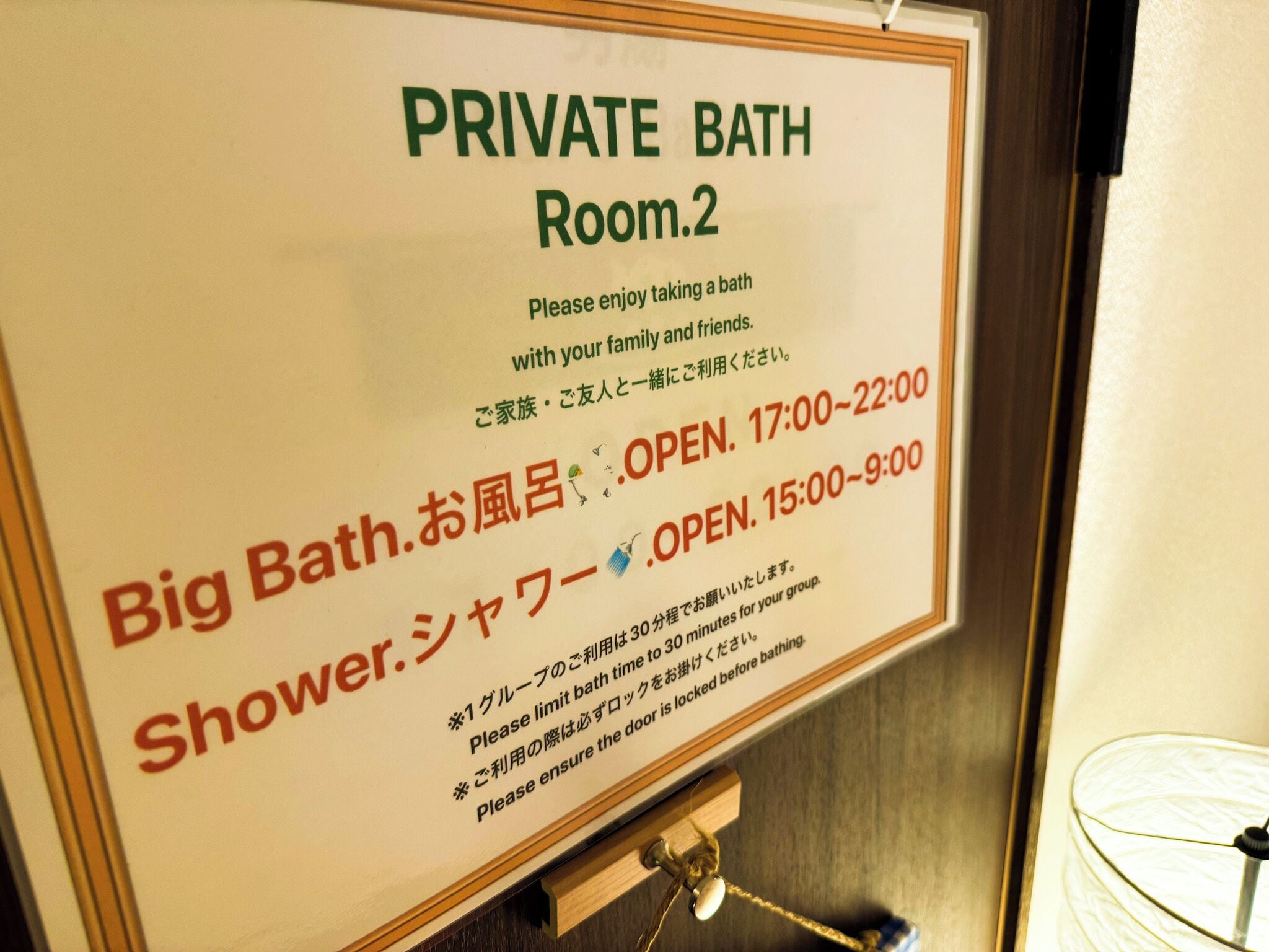 Schild für ein privates Badezimmer, Raum 2, mit Öffnungszeiten und der Bitte, die Badezeit auf 30 Minuten zu beschränken.