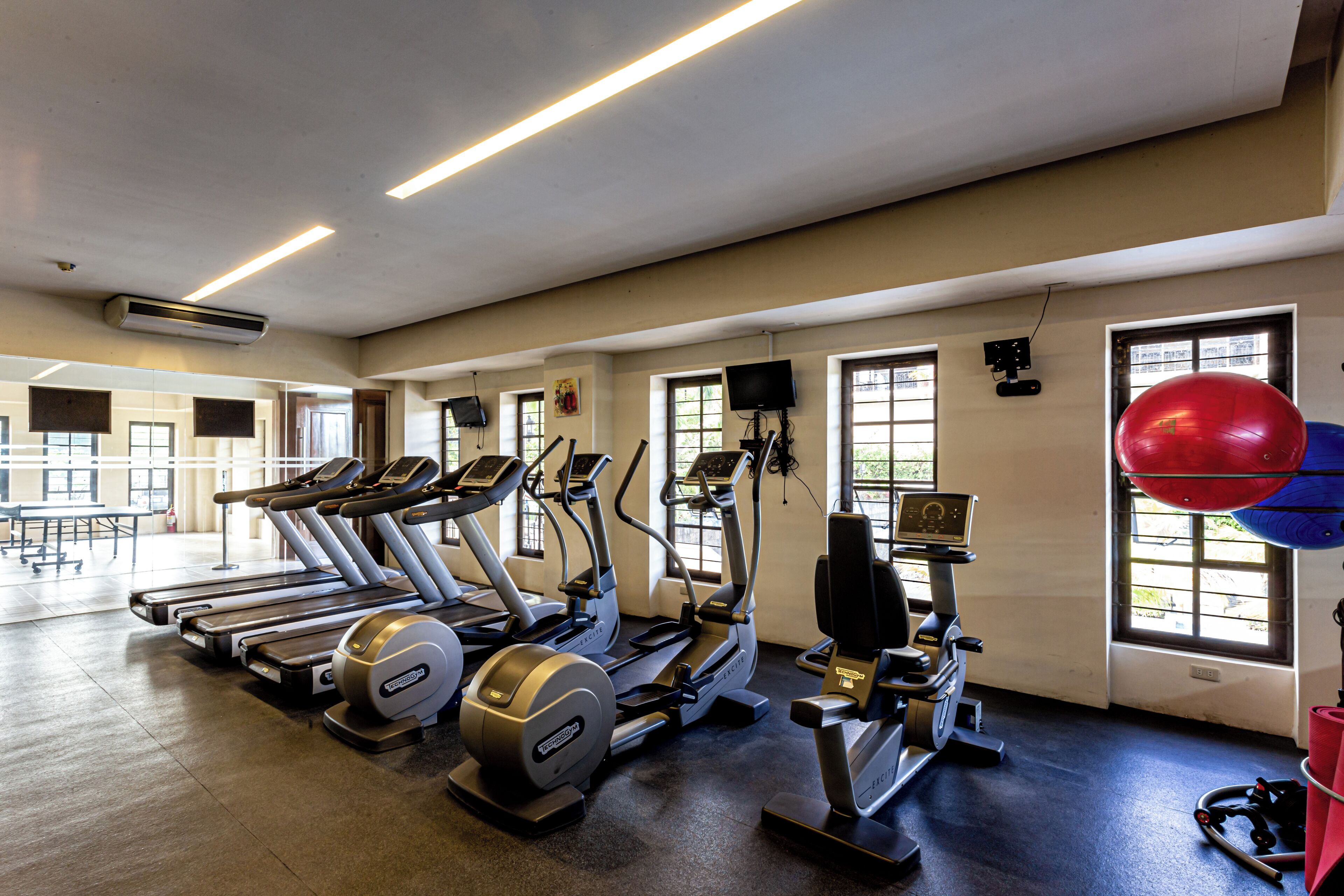 A gym with treadmills, elliptical machines, and a stationary bike.