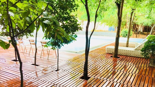 Una terraza de madera con sillas y una pequeña zona de estar.