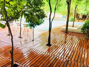 Una terraza de madera con sillas y una pequeña zona de estar.