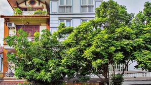 Un hotel con fachada moderna, balcones y un letrero que indica Hotel Ngoc Anh.