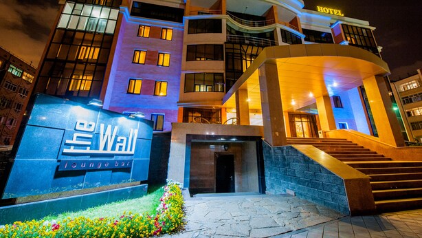A hotel with a prominent entrance, a lounge bar sign, and a staircase leading to the entrance.