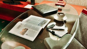 A table with a magazine, a cup of coffee, a pen, and a wallet. - Goldman Empire (Astana)