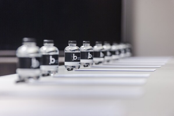 A row of identical bottles with a label on a table. - Hôtel b design & Spa (Paradou)