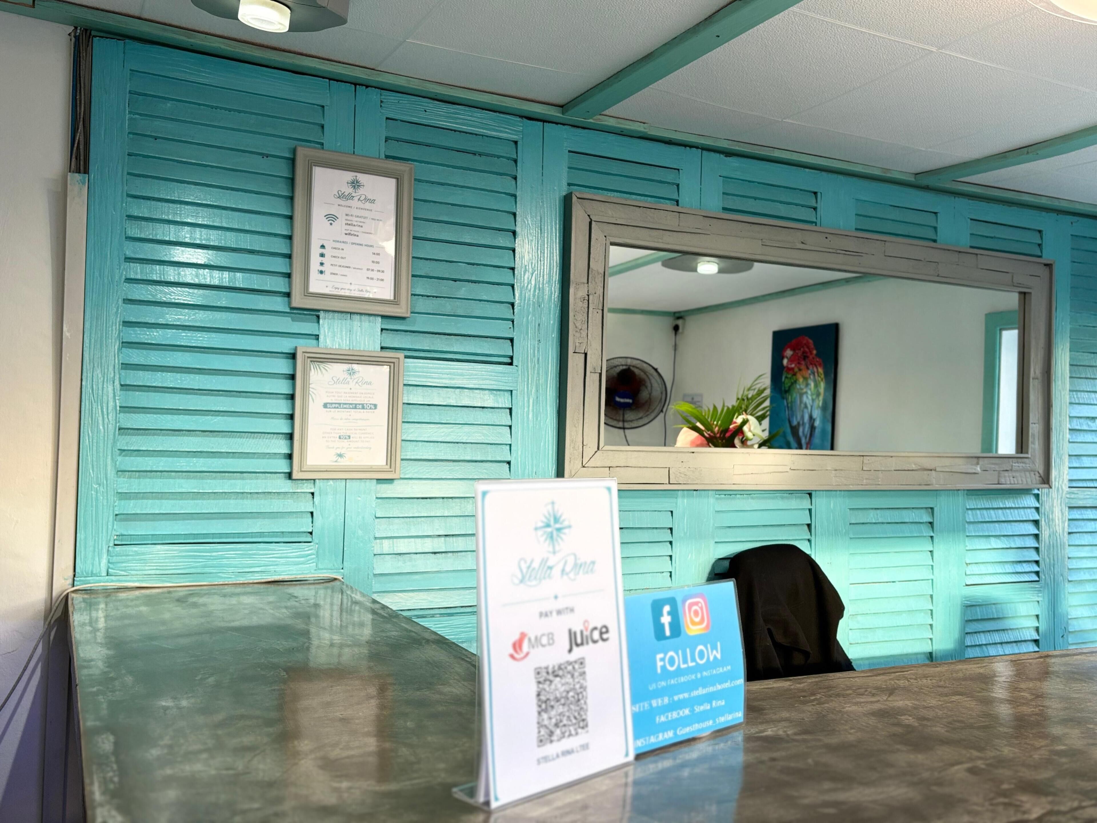 A reception desk with a framed certificate, a mirror, and a sign promoting social media.