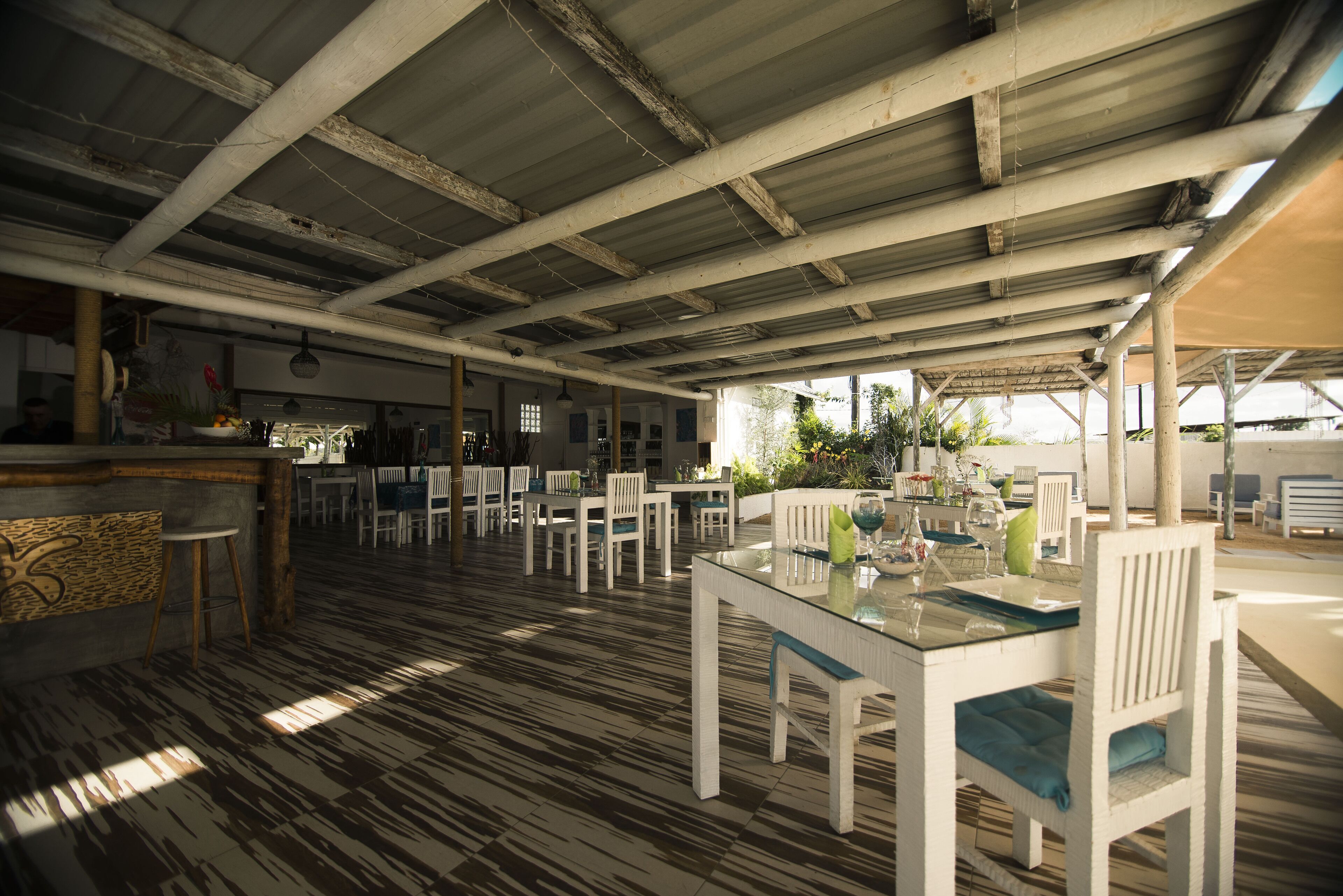 Un restaurant à espace ouvert avec un haut plafond et des poutres apparentes, proposant différents types d’aménagements, notamment des tables et des chaises.