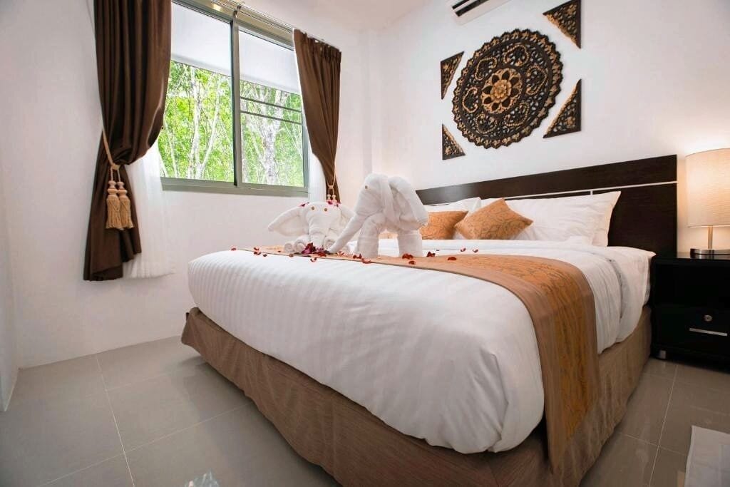Una habitación de hotel con una cama grande, una mesita de noche y una pared con diseños decorativos.