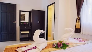 Une chambre d’hôtel avec un lit, une armoire, une porte et un rideau.