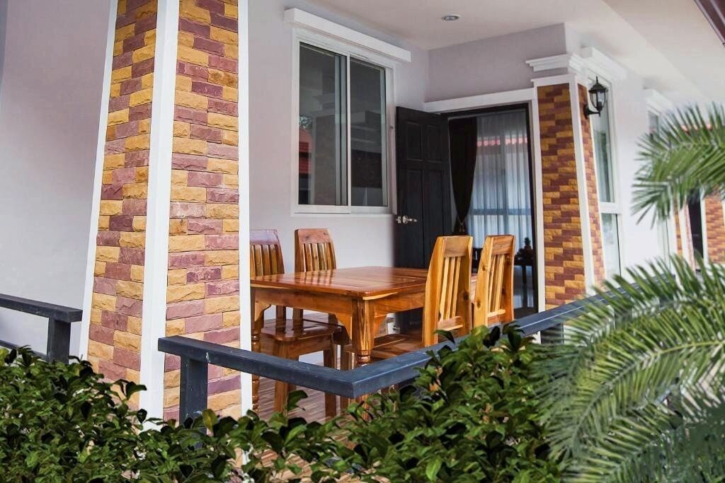 A wooden dining table with chairs, a window, and a door with curtains.