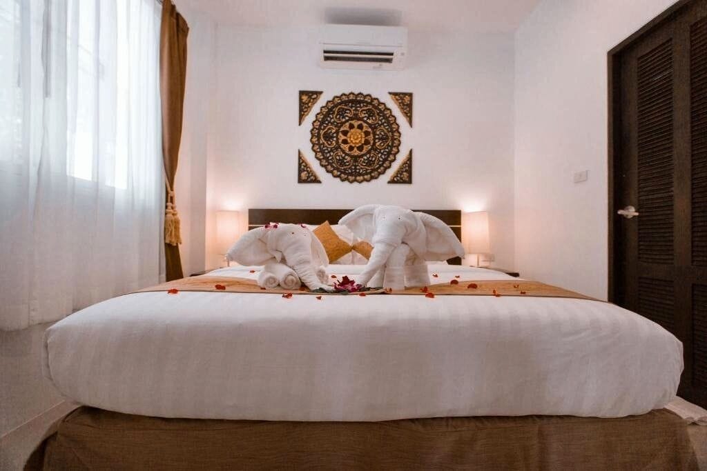 Ein Hotelzimmer mit einem Bett, einer Wanddekoration und einer Klimaanlage.