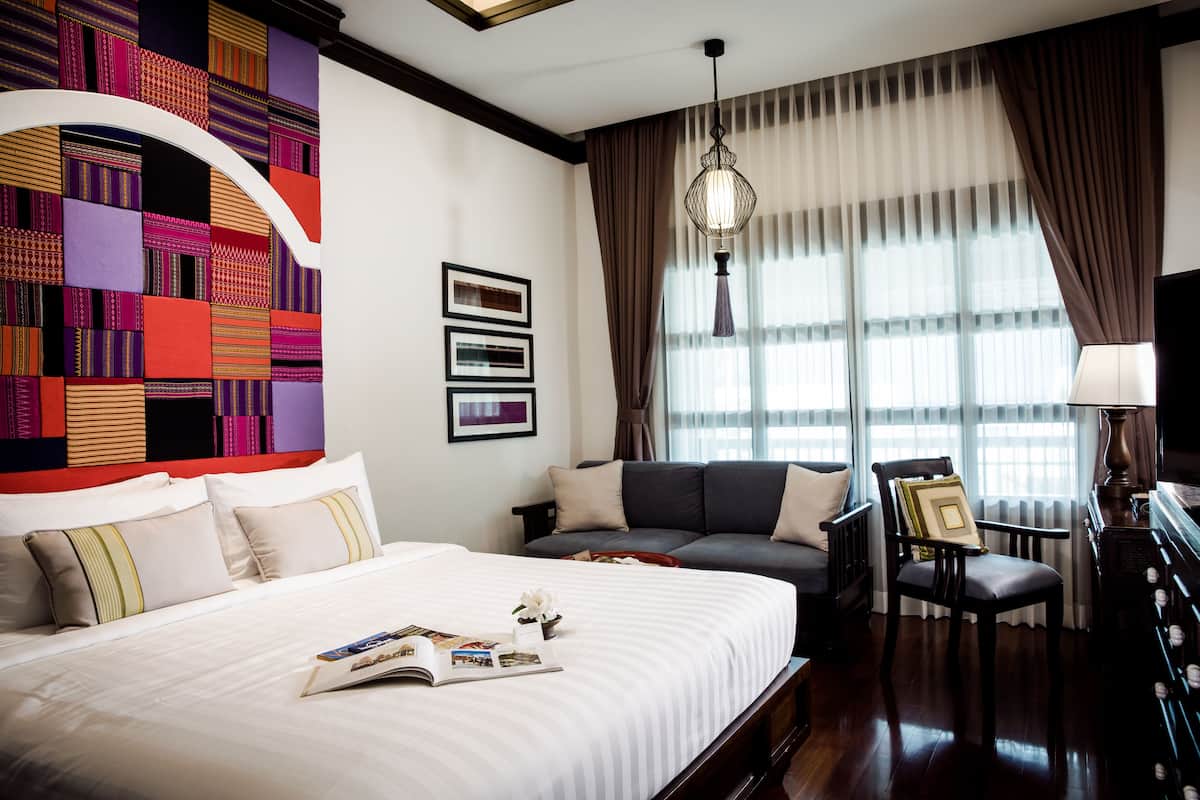 Een hotelkamer met een groot bed, een bank, een stoel en een televisie.
