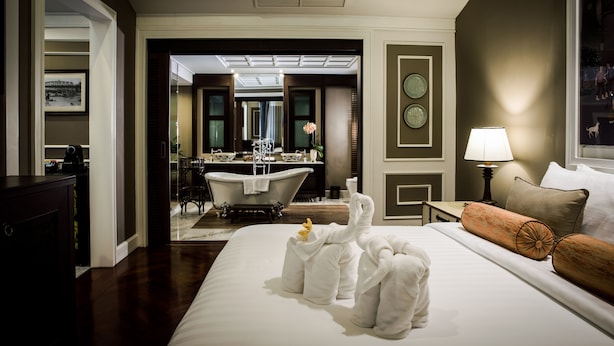 Hotelkamer met een groot bed, een badkamer met bad, een zithoek en uitzicht.
