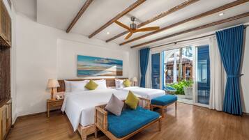 A hotel room with a large bed, two bedside tables, a ceiling fan, and a view of the outdoors.