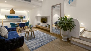 A modern living room with a large window, a dining area, and a staircase. - Risemount Premier Resort Da Nang (Da Nang)