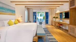 A modern hotel room with a large bed, a desk, and a view of the outdoor balcony. - Risemount Premier Resort Da Nang (Da Nang)