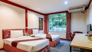 Ein Hotelzimmer mit zwei Betten, einem Esstisch und einem Fernseher.