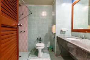 Ein Badezimmer mit Toilette, Dusche, Waschbecken und Spiegel.