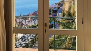 A room with a large arched window overlooking a coastal view. - La Dolce Vita Ravello (Ravello)