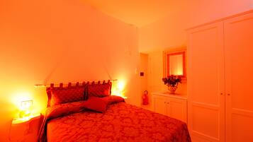 Un dormitorio con cama, mesitas de noche, cómoda y espejo.
