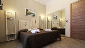 Habitación de hotel con una cama grande, un armario, un espejo y un cuadro en la pared.