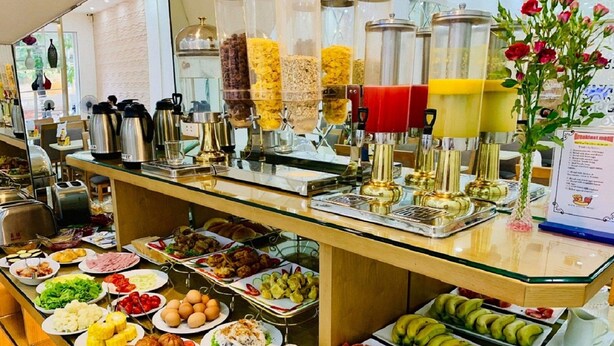 A buffet with various food items and a coffee station.