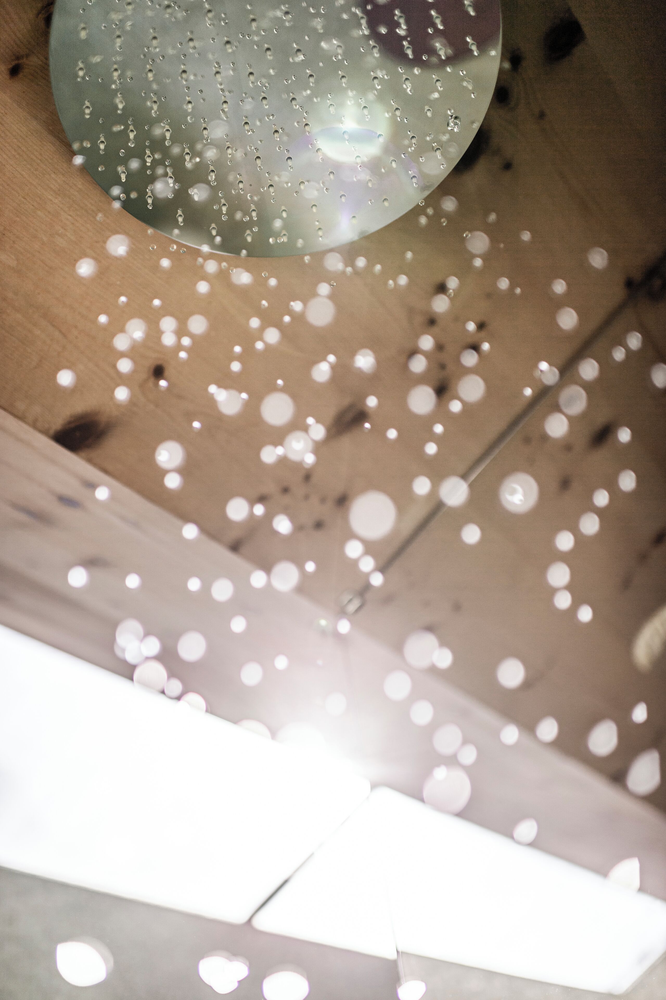 Un plafond orné d’un luminaire sphérique et d’une poutre en bois.