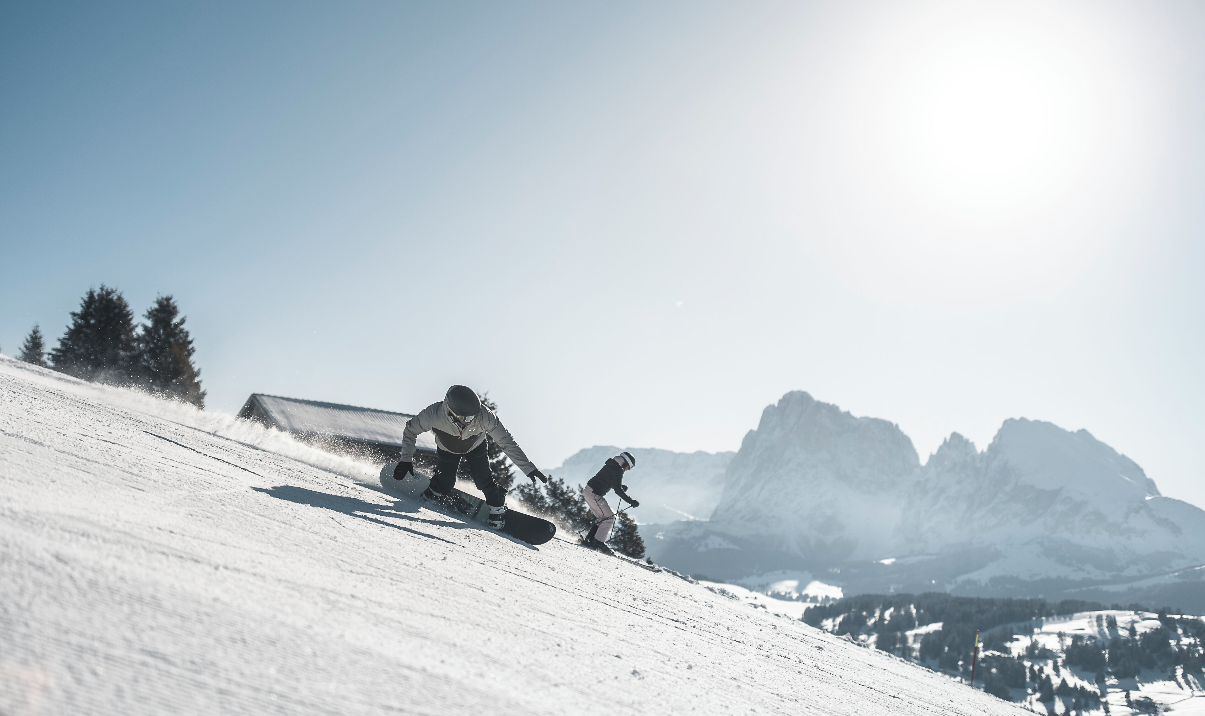 A snowy mountain slope with a snowboarder in motion.