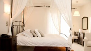 A bedroom with a bed, a nightstand, a chair, a desk, and a mirror. - Sea Sight Hotel (Markopoulo Mesogaias)