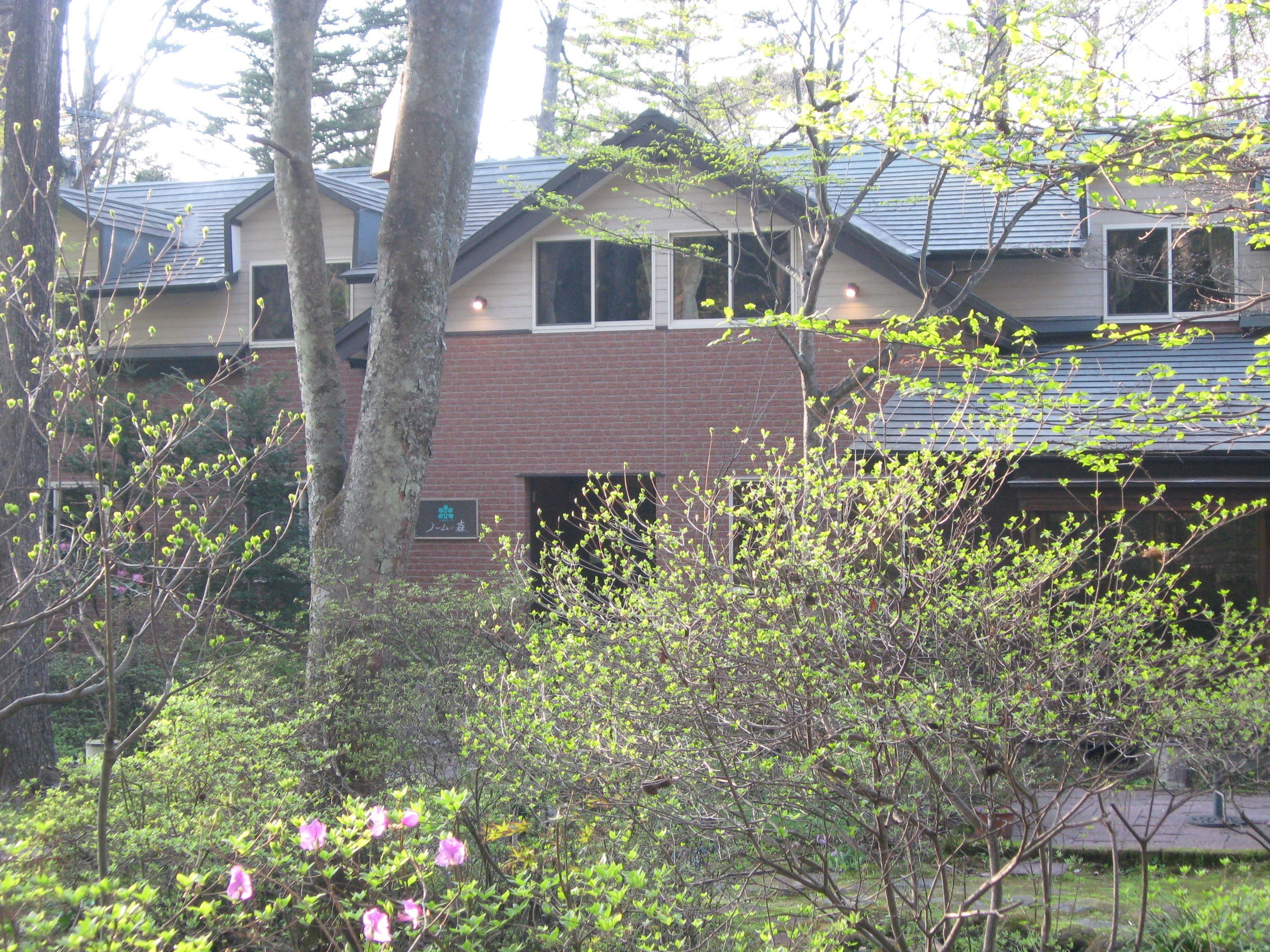 A building with a brick facade, large windows, and a sloped roof.