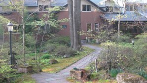 A residential area with a brick building, a pathway, and surrounding greenery.