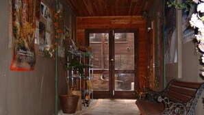 A hallway with a bench, a door, and a tiled floor.