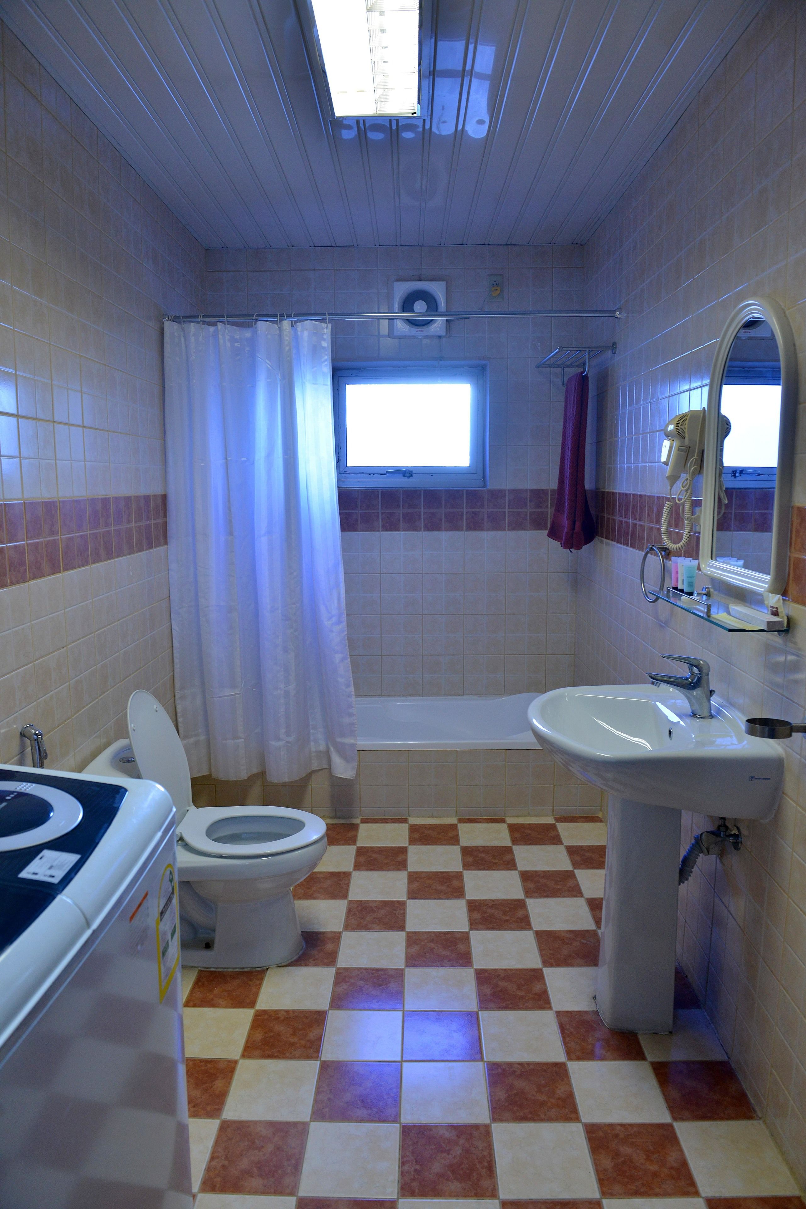 A bathroom with a toilet, sink, and bathtub.