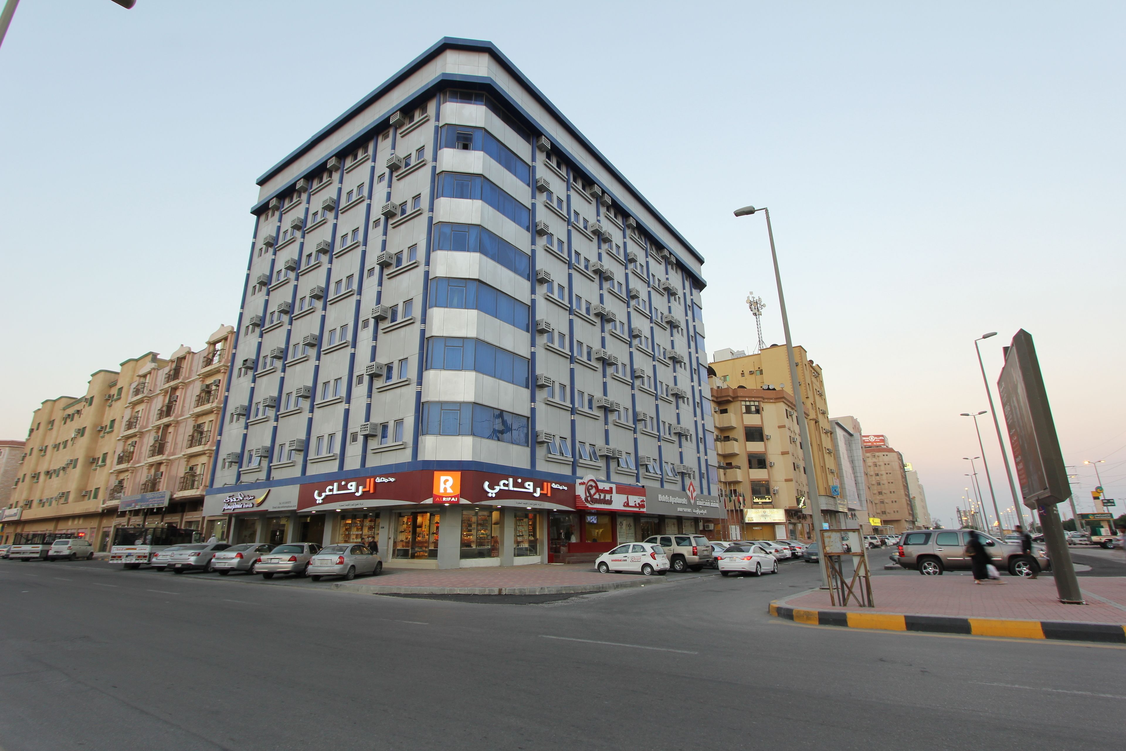 Un hôtel à plusieurs étages au design moderne, doté de balcons et situé à un carrefour.