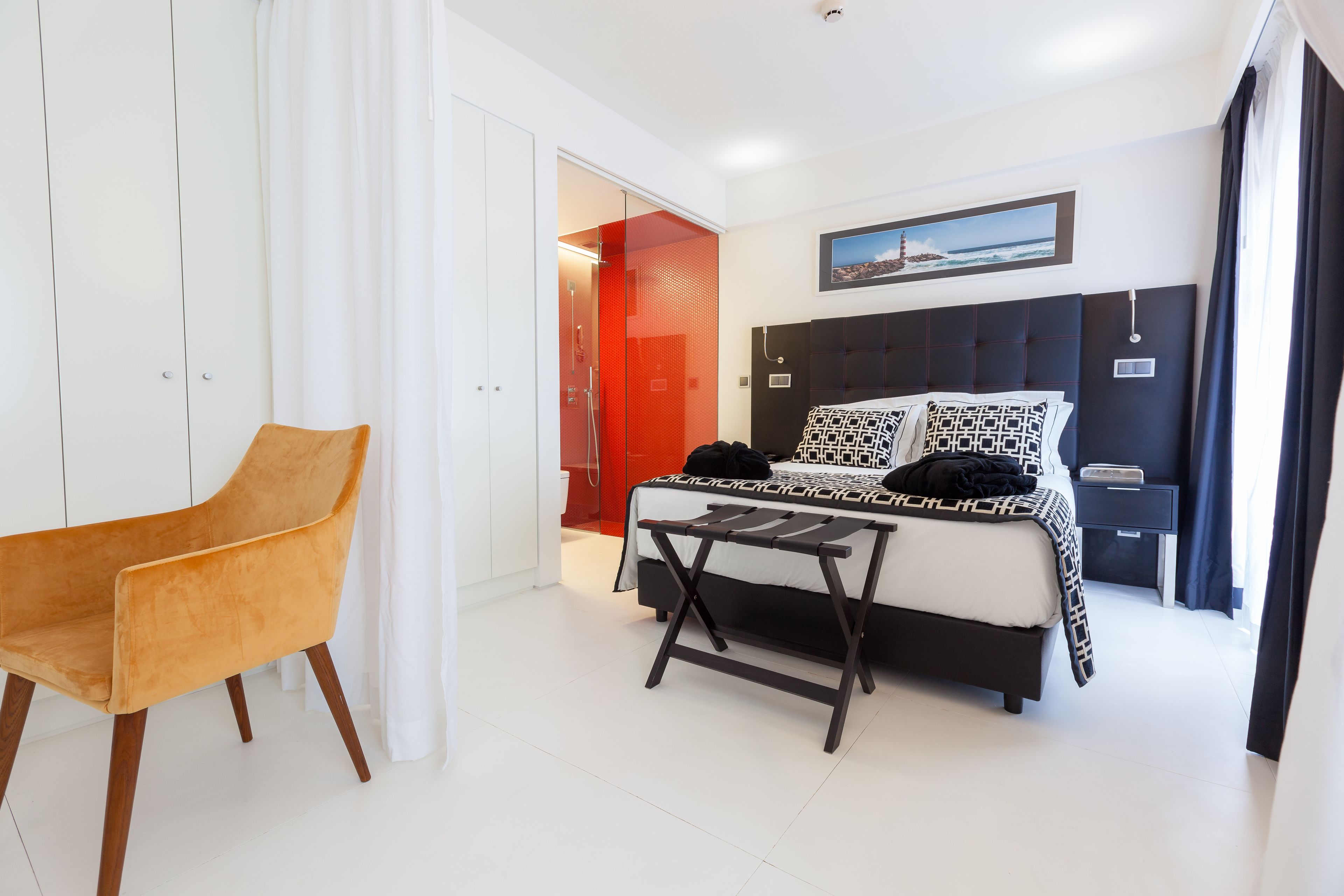 Un dormitorio moderno con cama, una silla y una mesita.
