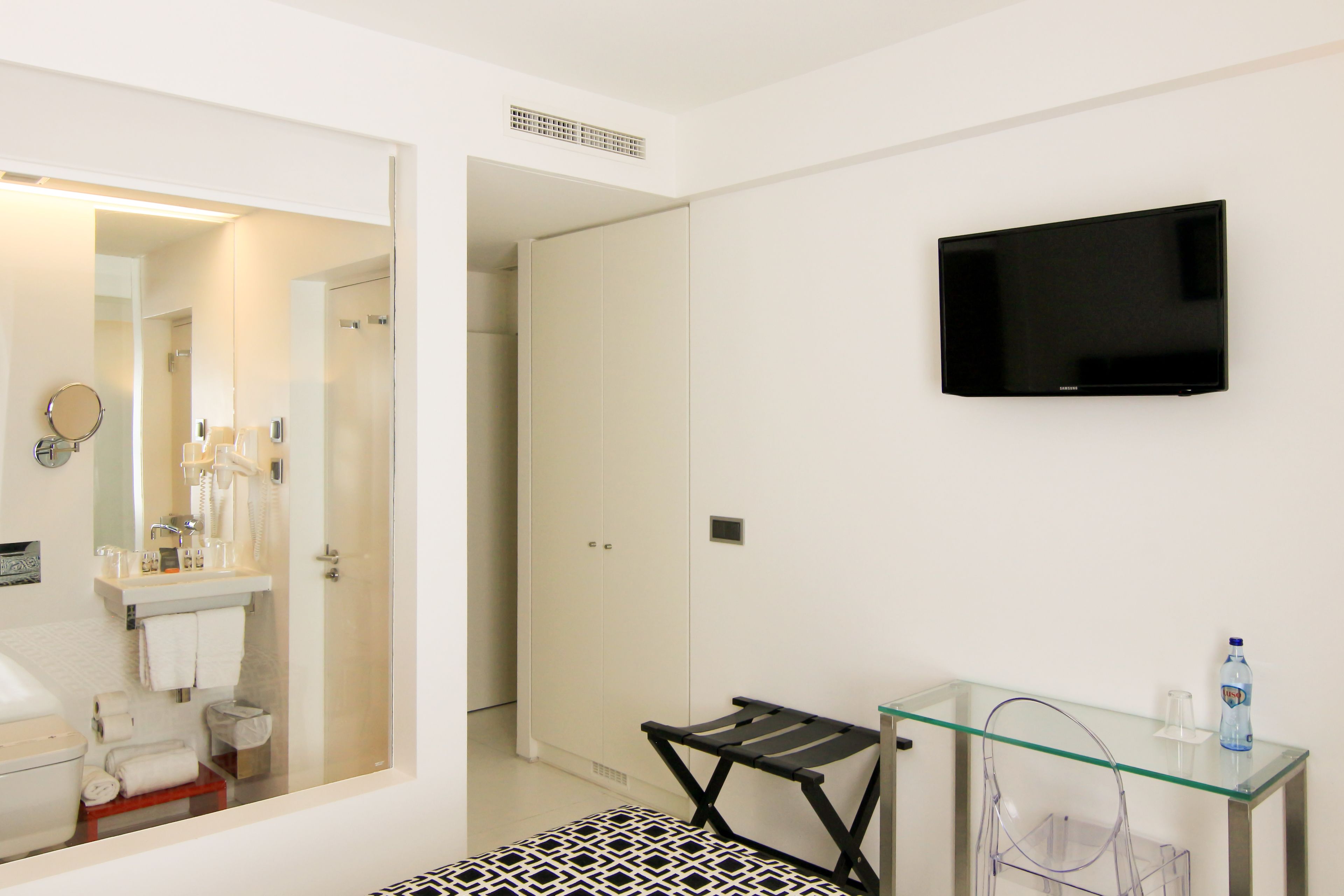 A modern bathroom with a glass shower enclosure, a toilet, and a sink.