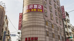 A hotel with a curved facade, multiple windows, and signage indicating it is a hotel with amenities like a restaurant and a spa. - Good Hotel (Taichung)