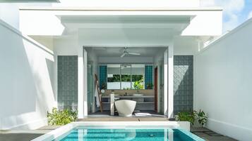 Piscina exterior moderna com vista para uma casa de banho e um ventilador de teto.
