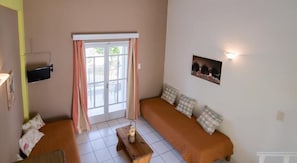 Habitación, vista a la alberca (Duplex) | Área de sala de estar | Televisión de plasma