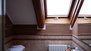 A skylight in a bathroom with a tiled wall and a radiator. - La Fertè Hotel (Asti)