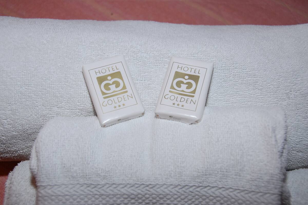 Two white hotel keycards labeled "HOTEL GOLDEN" on a white towel.