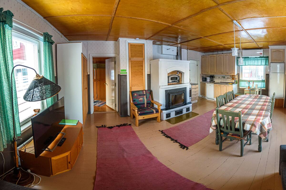Una sala acogedora con chimenea, muebles de madera y un comedor.