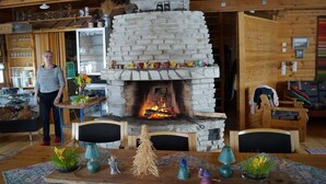 A cozy room with a stone fireplace, wooden furniture, and a variety of decorative items. - Holiday Village Kuukiuru (Kemijarvi)
